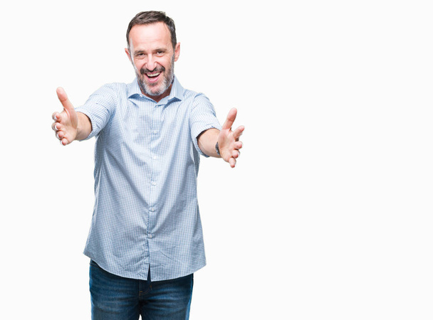 Middle age hoary senior business man over isolated background looking at the camera smiling with open arms for hug. Cheerful expression embracing happiness. - Photo, Image