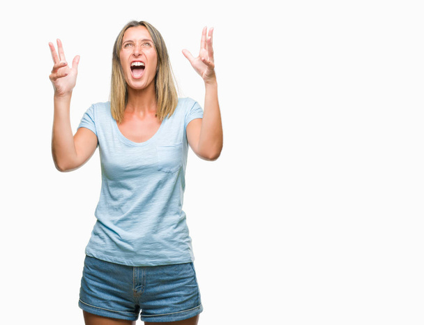 Young beautiful woman over isolated background crazy and mad shouting and yelling with aggressive expression and arms raised. Frustration concept. - Foto, immagini