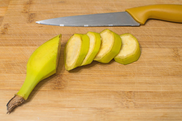 Ripe banana on a wooden board. Juicy sweet banana slices on wooden board. - Foto, Imagem