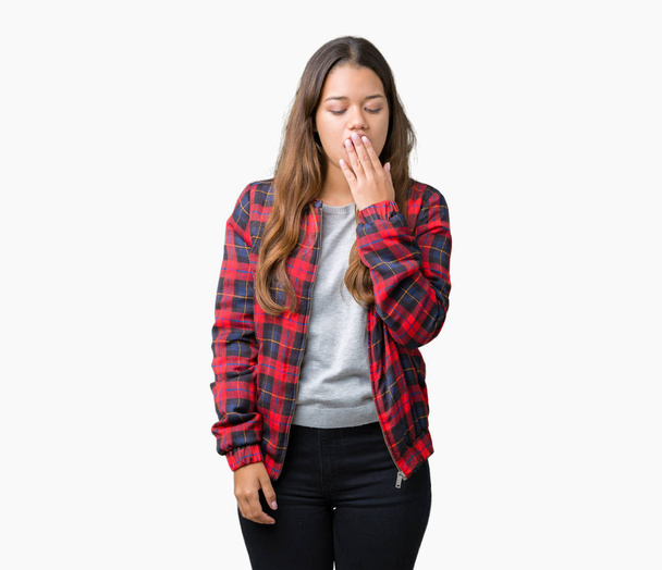 孤立した背景の上にジャケットを着て若い美しいブルネットの女性は、手で口を覆っている疲れてあくび退屈。落ち着きと眠気. - 写真・画像