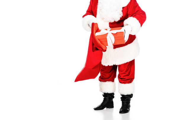 cropped shot of santa claus putting gift box into bag isolated on white - Fotoğraf, Görsel
