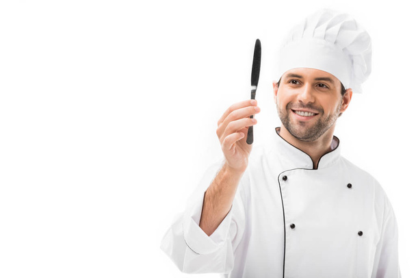 feliz joven chef sosteniendo cuchillo aislado en blanco
 - Foto, imagen