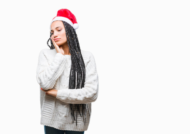 Молодий плетені волосся афро-американських дівчина носіння капелюхи Різдво над ізольованих фон мислення дивлячись втомився і нудно з депресією проблеми з схрещеними руками. - Фото, зображення