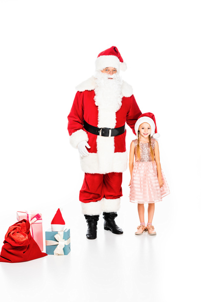 Père Noël Claude et petit enfant avec des boîtes-cadeaux regardant la caméra isolée sur blanc
 - Photo, image