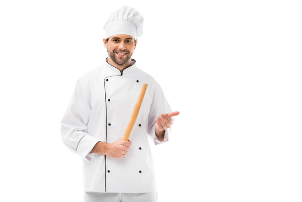 smiling young chef with rolling pin looking at camera isolated on white - Foto, imagen