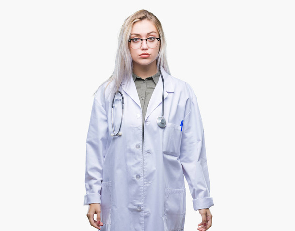 Young blonde doctor woman over isolated background depressed and worry for distress, crying angry and afraid. Sad expression. - Foto, imagen