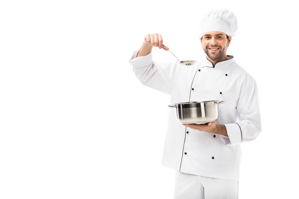 sonriente joven chef con olla y cucharón aislado en blanco
 - Foto, Imagen