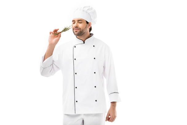 όμορφος νεαρός σεφ μυρίζοντας χορτάρι θυμάρια απομονωθεί σε λευκό - Φωτογραφία, εικόνα