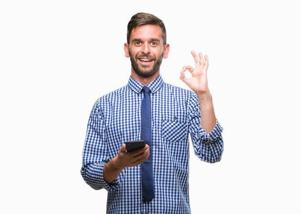 Mladí musela muž SMS odesílání zpráv pomocí smartphone izolované pozadí dělá ok cedulka s prsty, vynikající symbol - Fotografie, Obrázek