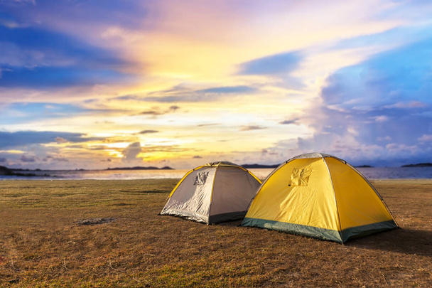 tenda amarela perto do lago em nuvens dramáticas
 - Foto, Imagem