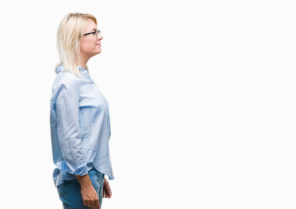 junge schöne blonde Geschäftsfrau trägt Brille über isoliertem Hintergrund zur Seite schauen, entspannen Profil Pose mit natürlichem Gesicht mit selbstbewusstem Lächeln. - Foto, Bild