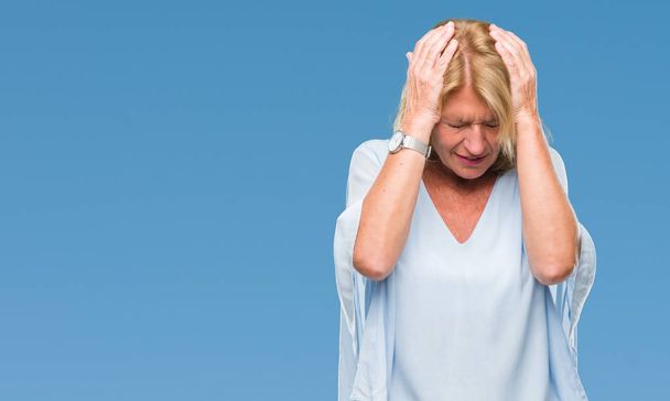 Keski-ikä blondi liiketoiminnan nainen yli eristetty tausta kärsii päänsärky epätoivoinen ja korosti, koska kipu ja migreeni. Kädet pään päälle.
. - Valokuva, kuva
