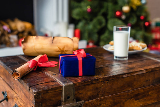 close-up view of parchment, gift box and glass of milk with cookies on chest - Photo, Image