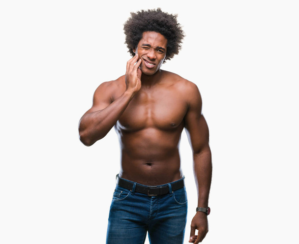 Afro Amerikaanse shirtless man naakt lichaam tonen over geïsoleerde achtergrond mond met de hand met pijnlijke expressie vanwege kiespijn of tandheelkundige ziekte op tanden aan te raken. Tandarts concept. - Foto, afbeelding