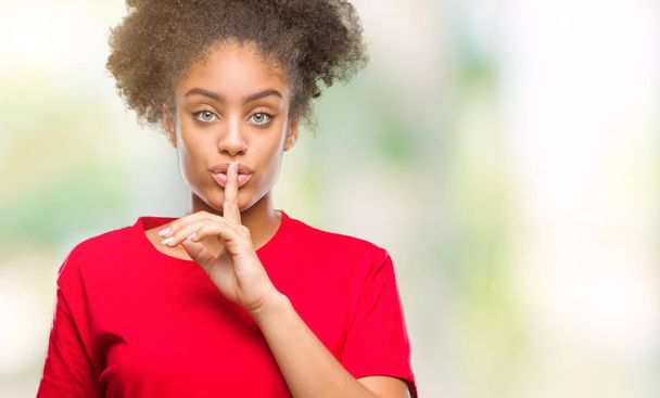 Young afro american woman over isolated background asking to be quiet with finger on lips. Silence and secret concept. - Foto, Imagen