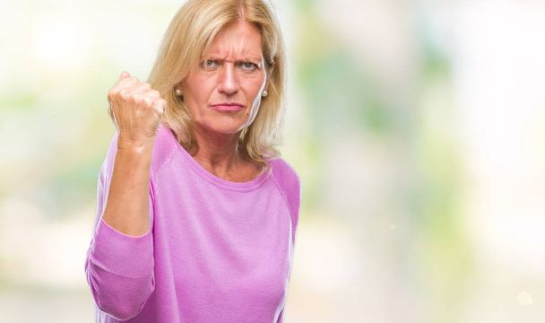 Blonde Frau mittleren Alters mit isoliertem Hintergrund, wütend und wütend die Faust reckend frustriert und wütend, während sie vor Wut schreit. Wut und aggressives Konzept. - Foto, Bild