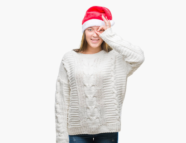 手の笑顔、幸せそうな顔で指を通して見る目で ok のジェスチャーを行う分離の背景にクリスマスの帽子をかぶって若い美しい白人女性. - 写真・画像