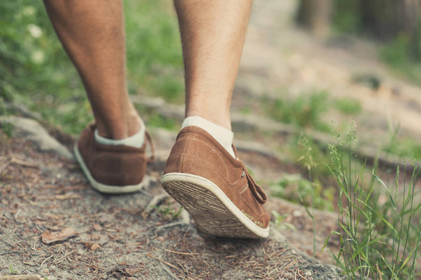 Primo piano di scarpe uomo che camminano nella foresta
 - Foto, immagini