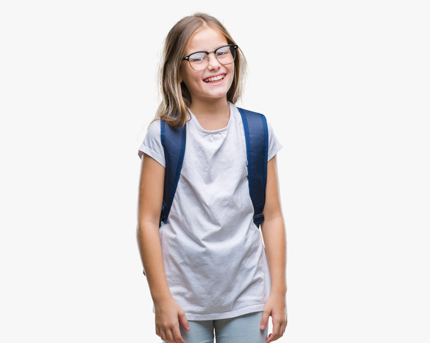 Young beautiful smart student girl wearing backpack over isolated background looking away to side with smile on face, natural expression. Laughing confident. - Foto, imagen