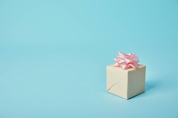 Coffret cadeau avec arc rose sur fond bleu
 - Photo, image