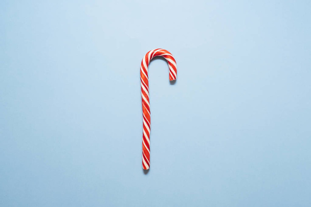 Christmas candy cane on blue background. Flat lay, top view, overhead. - Valokuva, kuva