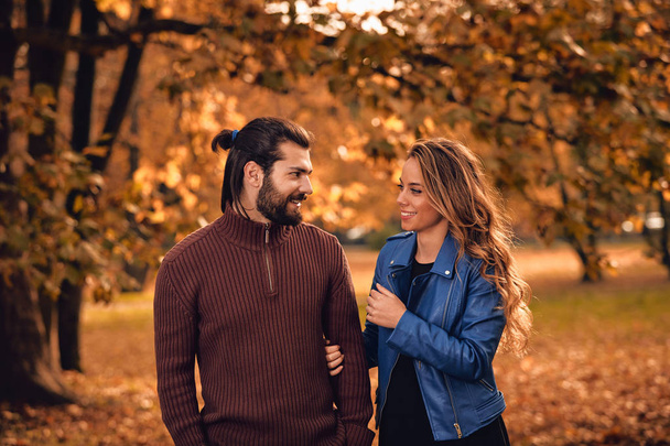 Couple in autumn season colored park enjoying outdoors. - Фото, изображение