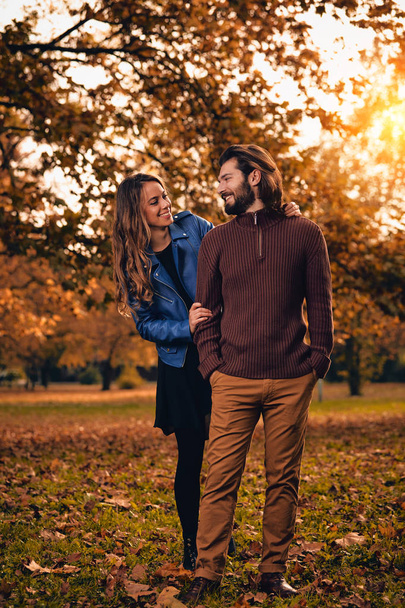 Couple in autumn season colored park enjoying outdoors. - Φωτογραφία, εικόνα