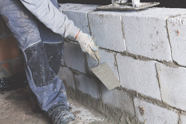 Real construction worker bricklaying the wall using tools. - Photo, Image