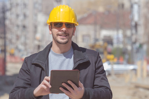 Bauarbeiter posiert mit Tablet im Freien. - Foto, Bild