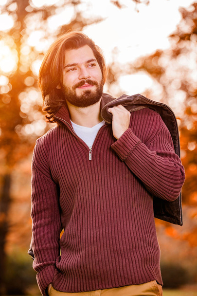Όμορφος νεαρός φορώντας δερμάτινο μπουφάν στη φθινοπωρινή σεζόν / κρύο καιρός. - Φωτογραφία, εικόνα