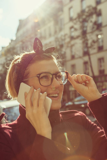 Девушка разговаривает по телефону в городской среде
. - Фото, изображение