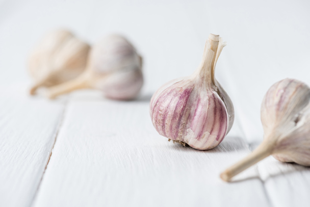 Garlic bulbs on white wooden table - Fotó, kép