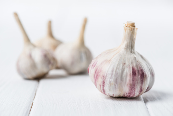 Ripe garlic bulbs on white wooden table - Foto, immagini