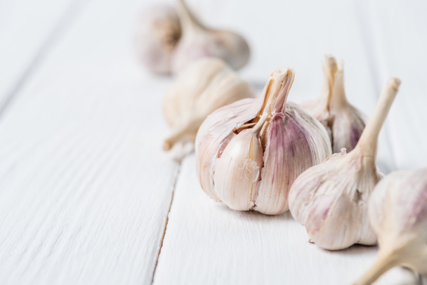 Several ripe garlic bulbs on white rustic table - Zdjęcie, obraz