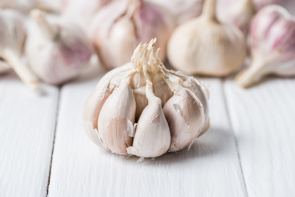 Ripe garlic bulb with cloves on white rustic table - Zdjęcie, obraz