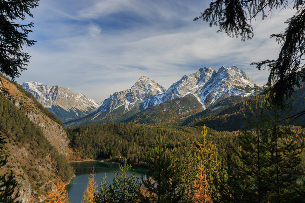 Vista panorámica de las montañas de Mieminger en los Alpes europeos vistas desde Fernpass con Ehrwalder Sonnenspitze, Gruenstein y el lago Blindsee en primer plano en un día soleado de otoño
 - Foto, imagen