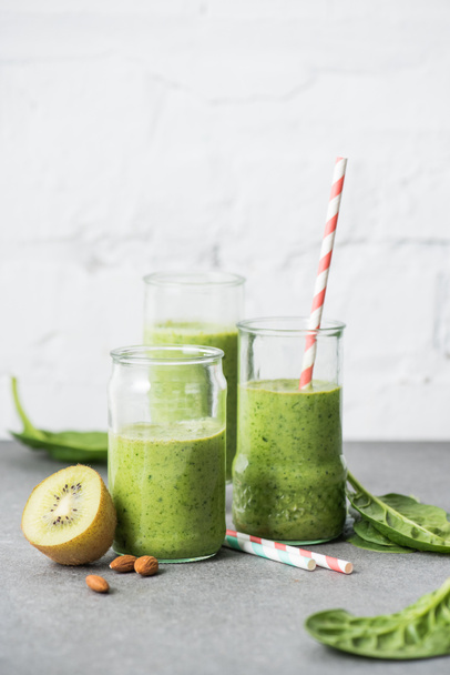 Πράσινο και υγιή οργανική smoothie σε ποτήρια με καλαμάκια - Φωτογραφία, εικόνα