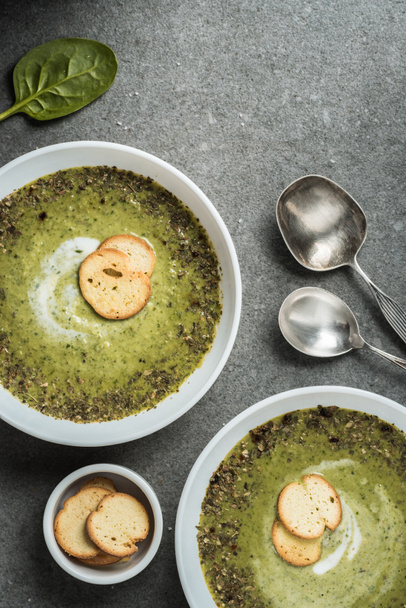 Top view of two bowls with green creamy spinach soup and croutons - Foto, Imagen