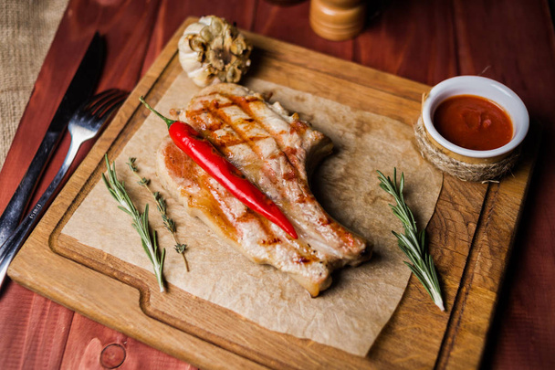 roasted beef rib with pepper and rosemary on wooden board - Photo, image
