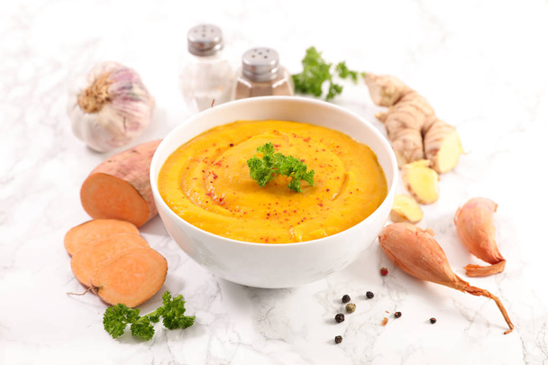 Sweet potato soup with ginger root and garlic on table - Photo, image