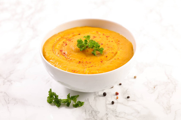 Bowl of seasonal pumpkin soup with green herb - Photo, image