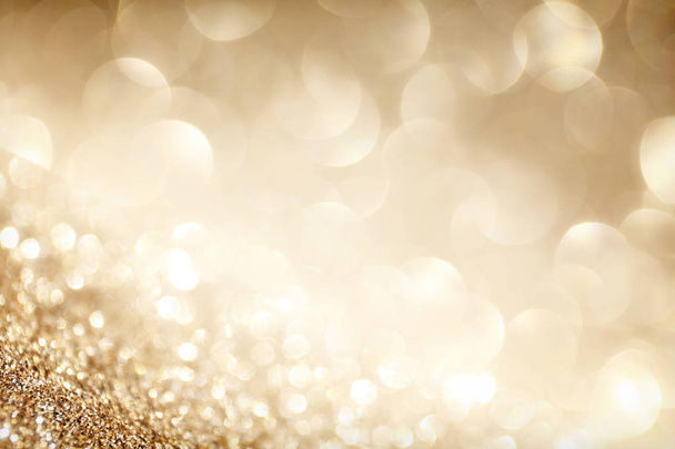 Golden sparkle glitters with bokeh effect and selectieve focus. Festive background with bright gold lights, champagne bubble. Christmas mood concept. Copy space, close up, texture, top view. - Fotografie, Obrázek