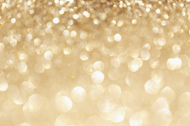Gouden schittering blinkt met bokeh effect en selectieve aandacht. Feestelijke achtergrond met felle gouden lichten, champagne zeepbel. Kerst sfeer concept. Kopie ruimte, close-up, textuur, bovenaanzicht. - Foto, afbeelding