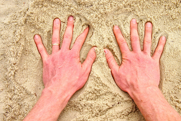 Дорослий рука малювання пальцем на піску символ. Піщаний пляж - Фото, зображення