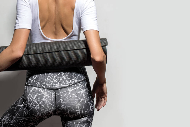 Athletic woman with yoga mat over grey background - Zdjęcie, obraz