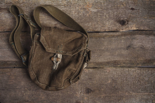 Old army bag, military uniform on a wooden background with copy space, flat lay top view - Foto, Imagem