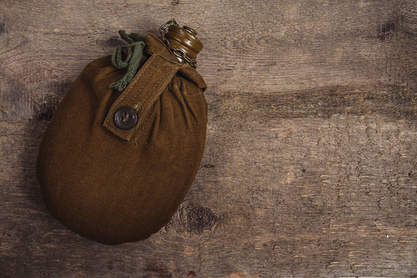 Old army flask, military uniform on wooden background with copy space, flat lay top view - Foto, Bild