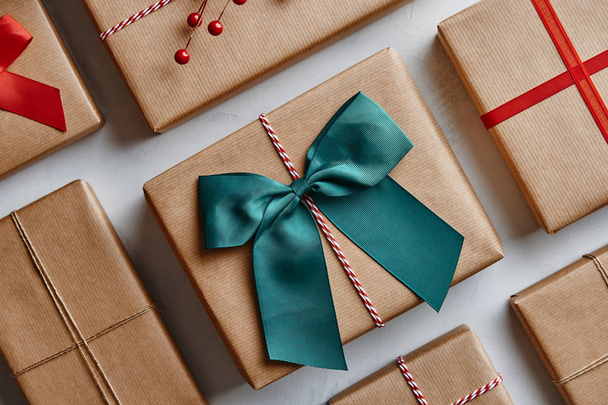 Χριστουγεννιάτικα δώρα τυλιγμένο σε καφέ χαρτί και διακοσμημένα με τόξα και κορδέλες. Από πάνω - Φωτογραφία, εικόνα