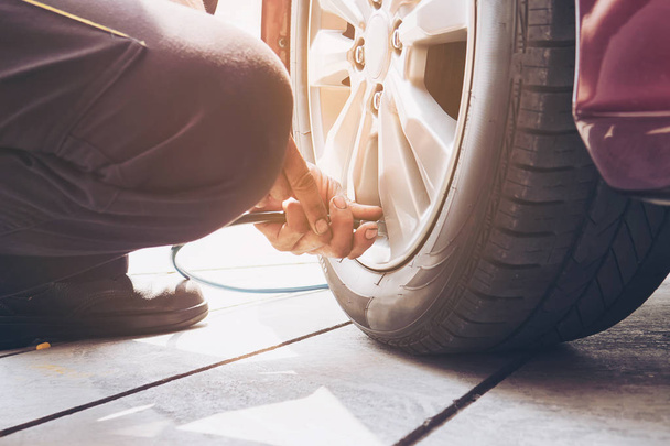 Technician is inflate car tire - car maintenance service transportation safety concept - Fotó, kép