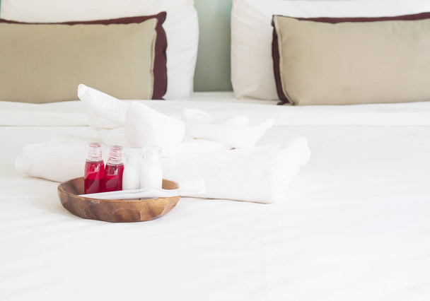 Hotel towel set with toothbrush and toothpaste on white bed - Fotografie, Obrázek